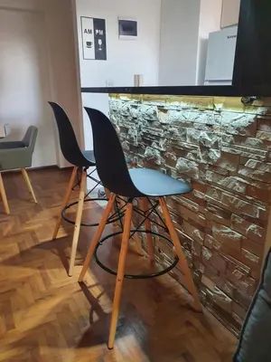 a room with two chairs and a stone wall at Alojamiento Maria :-) in Cordoba
