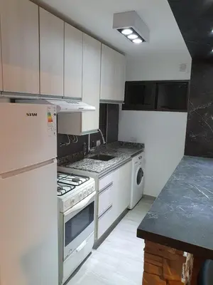 a kitchen with white cabinets and a stove top oven at Alojamiento Maria :-) in Cordoba