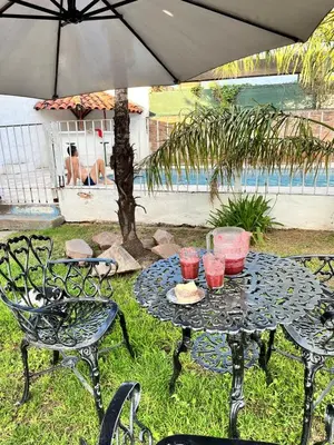 a patio table with two chairs and an umbrella at Hotel Andino in Villa Carlos Paz
