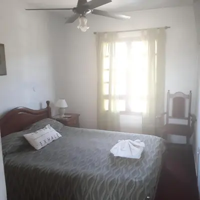 a bedroom with a bed and a ceiling fan at Hotel Andino in Villa Carlos Paz
