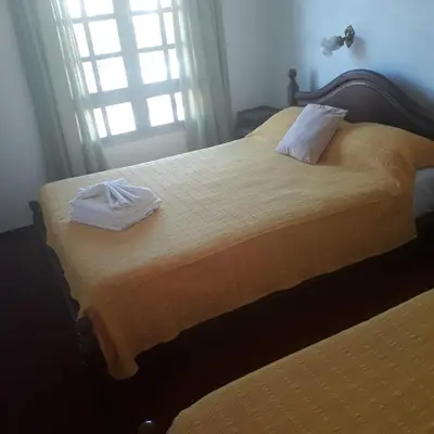 a bedroom with two beds with towels on them at Hotel Andino in Villa Carlos Paz