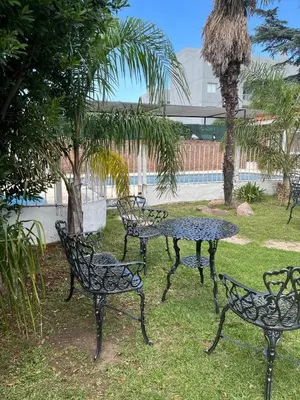 a group of tables and chairs in a park at Hotel Andino in Villa Carlos Paz