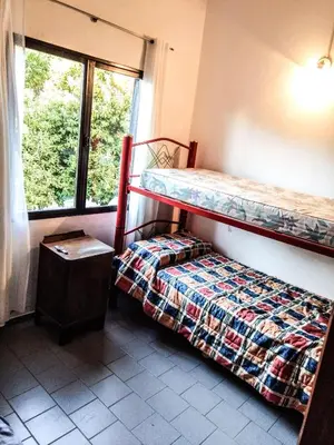 a bedroom with two bunk beds and a window at Dúplex frente al río en Playas de Oro in Villa Carlos Paz