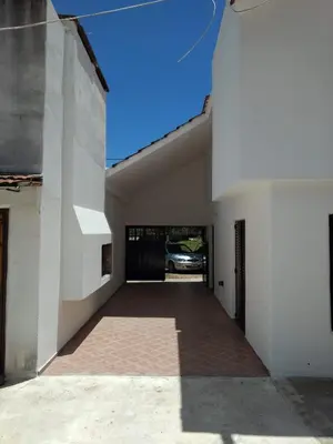 an empty hallway of a white building with a driveway at Dúplex frente al río en Playas de Oro in Villa Carlos Paz
