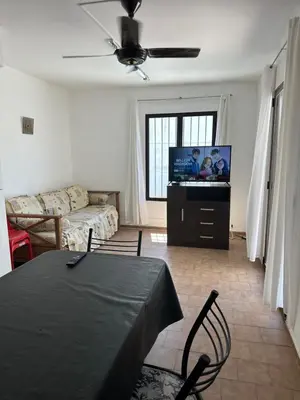 a living room with a couch and a flat screen tv at Dúplex frente al río en Playas de Oro in Villa Carlos Paz
