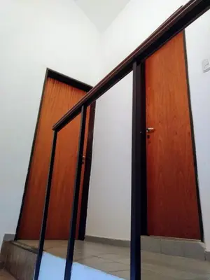 a set of stairs with a wooden door at Dúplex frente al río en Playas de Oro in Villa Carlos Paz
