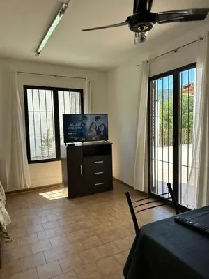 a living room with a flat screen tv and windows at Dúplex frente al río en Playas de Oro in Villa Carlos Paz