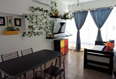 a dining room with a black table and chairs and a tv at DEPARTAMENTO MAGNET in Villa Carlos Paz