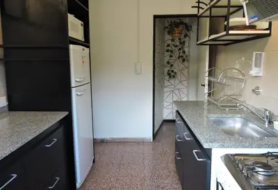 a kitchen with a sink and a white refrigerator at DEPARTAMENTO MAGNET in Villa Carlos Paz