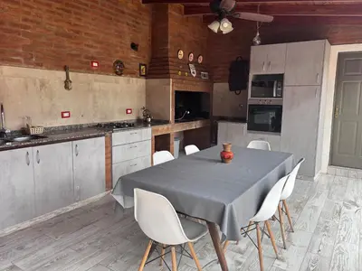 a kitchen with a table and white chairs in it at Alto Hermoso Apart in Cordoba
