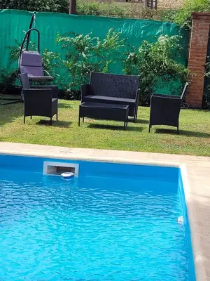 a swimming pool with two chairs and a swing at Alto Hermoso Apart in Cordoba