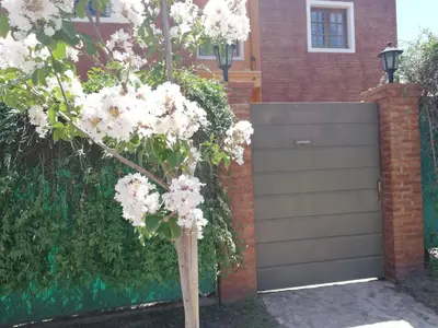a tree with white flowers in front of a garage at Alto Hermoso Apart in Cordoba