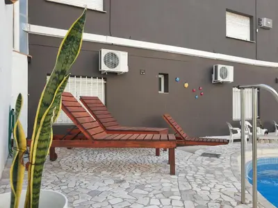 a patio with two chairs and a swimming pool at Hotel Brisas in Villa Carlos Paz