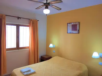 a bedroom with a bed and a ceiling fan at Hotel Brisas in Villa Carlos Paz