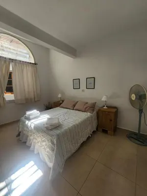 a bedroom with a bed and a fan and a window at Rivahome in Cordoba