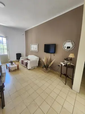 a living room with a bed and a flat screen tv at Rivahome in Cordoba
