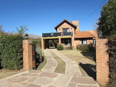 a brick house with a gate and a driveway at Chalet Individual Maiten 1 in Merlo