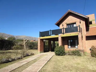 a brick house with a balcony on top of it at Chalet Individual Maiten 1 in Merlo