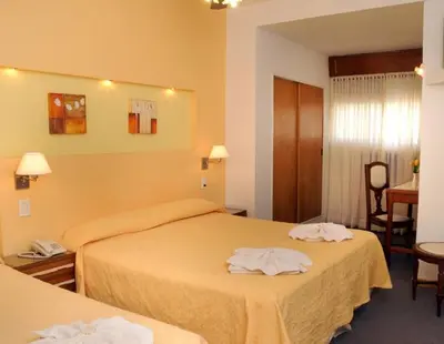 a hotel room with two beds with towels on them at Florida Hotel & Spa in Villa Carlos Paz