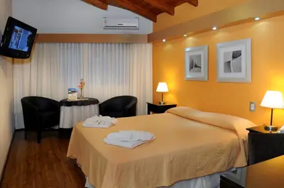 a hotel room with a bed and a table at Florida Hotel & Spa in Villa Carlos Paz