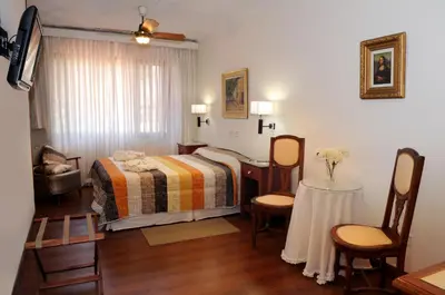 a bedroom with a bed and a table and chairs at Florida Hotel & Spa in Villa Carlos Paz