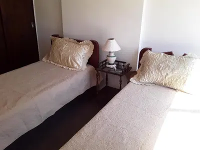 two beds in a room with a lamp on a table at Corro temporal in Cordoba