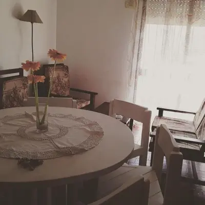 a dining room table with a vase with flowers on it at Corro temporal in Cordoba