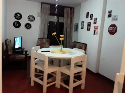 a white table with chairs and a vase with flowers on it at Corro temporal in Cordoba