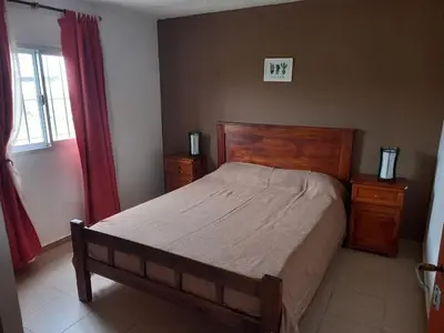 a bedroom with a bed and two dressers and a window at Cabañas Dayma in Trapiche