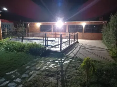 a building with a deck at night with lights at Cabañas Dayma in Trapiche