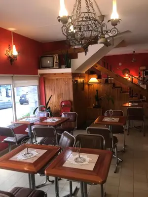 a restaurant with wooden tables and chairs in a room at HOTEL ESCORIAL in Villa Carlos Paz