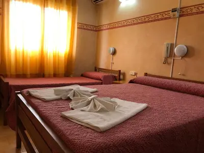 a hotel room with two beds with towels on them at HOTEL ESCORIAL in Villa Carlos Paz