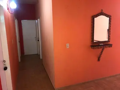 a hallway with an orange wall and a mirror at HOTEL ESCORIAL in Villa Carlos Paz