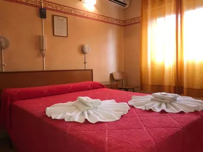 two towels on a red bed in a room at HOTEL ESCORIAL in Villa Carlos Paz