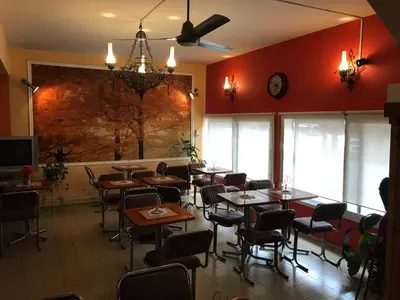 a restaurant with tables and chairs and a painting on the wall at HOTEL ESCORIAL in Villa Carlos Paz