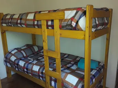 a wooden bunk bed with a bed in a room at Las Zarinas 3 in Trapiche
