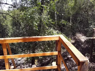 a wooden deck with trees in the background at Las Zarinas 3 in Trapiche
