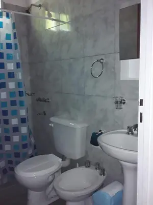 a bathroom with a white toilet and a sink at Las Zarinas 3 in Trapiche