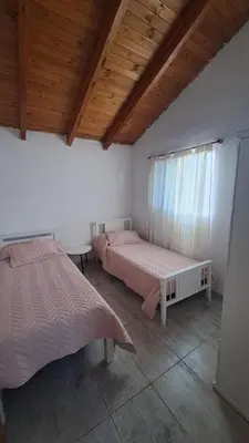 a bedroom with two beds and a wooden ceiling at Casa Villa Naturaleza in Villa Rumipal