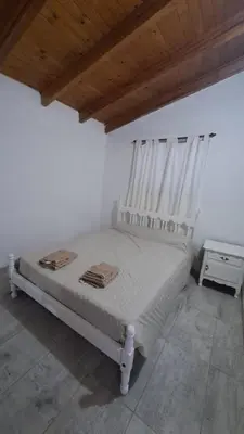 a white bed in a room with a wooden ceiling at Casa Villa Naturaleza in Villa Rumipal