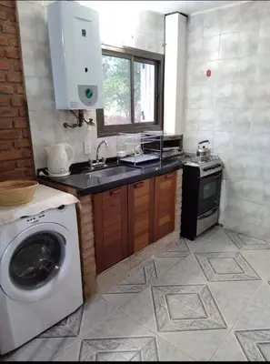 a kitchen with a washing machine and a sink at Casa Villa Naturaleza in Villa Rumipal
