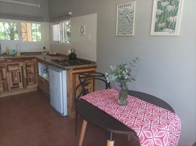 a kitchen with a table with a vase of flowers on it at Torito's House 3 in Tanti