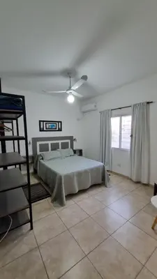 a white bedroom with a bed and a window at Amplio Dpto s/Av Rafael Nuñez - cerro de las rosas in Cordoba