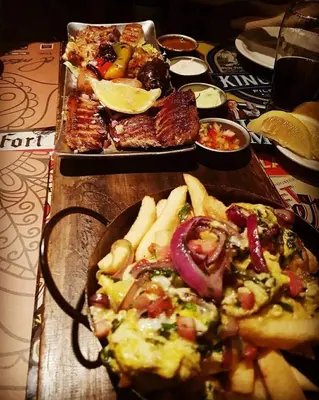 a table with a plate of pizza and other food at Amplio Dpto s/Av Rafael Nuñez - cerro de las rosas in Cordoba