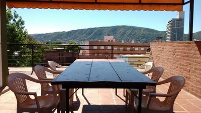 a wooden table and chairs on a balcony at Casas villa suiza con terraza in Villa Carlos Paz