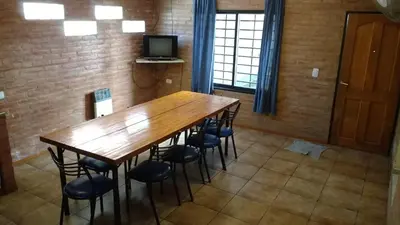 a dining room with a wooden table and chairs at Casas villa suiza con terraza in Villa Carlos Paz