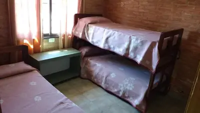 a room with two bunk beds and a table at Casas villa suiza con terraza in Villa Carlos Paz