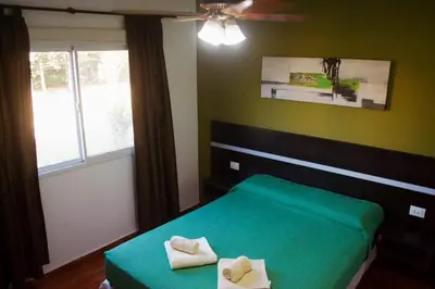 a bedroom with a green bed and a window at Aparts serranos in San Antonio de Arredondo