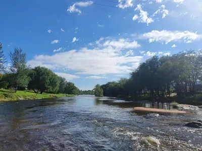 a river with trees and a blue sky with clouds at Aparts serranos in San Antonio de Arredondo