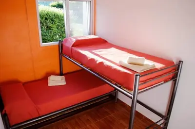 a red bunk bed in a room with a window at Aparts serranos in San Antonio de Arredondo